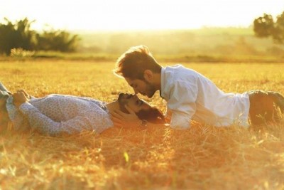 two guys kissing in a field