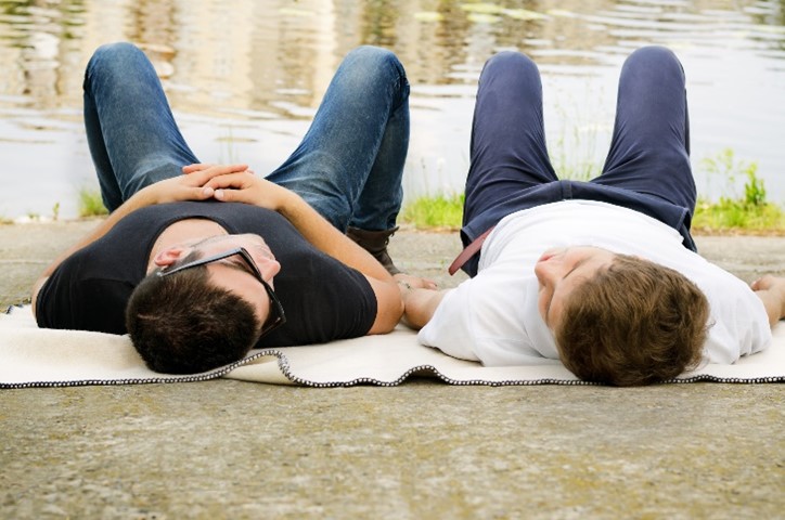 two men laying on their backs with their knees bent looking at each other
